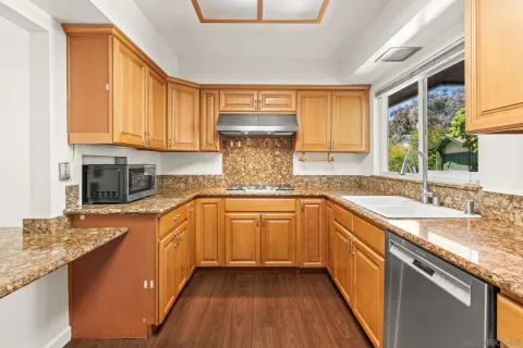 a kitchen with stainless steel appliances granite countertop a sink stove and cabinets