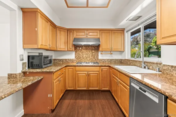 a kitchen with stainless steel appliances granite countertop a sink stove and cabinets