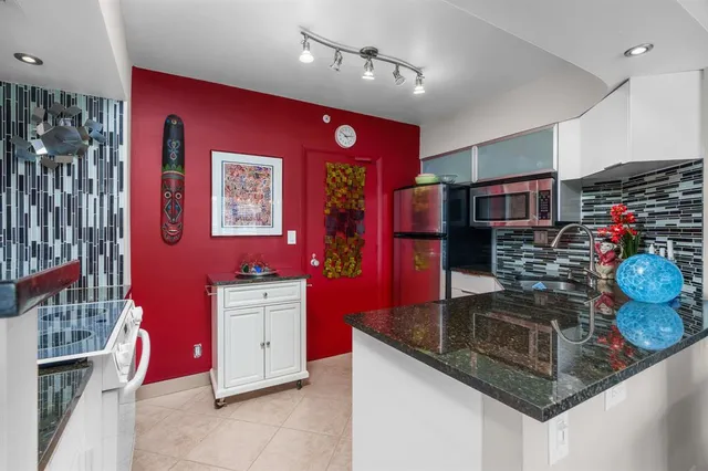 a kitchen with stainless steel appliances granite countertop a stove and cabinets