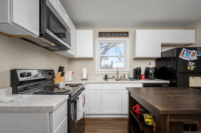 a kitchen with a table chairs refrigerator and microwave