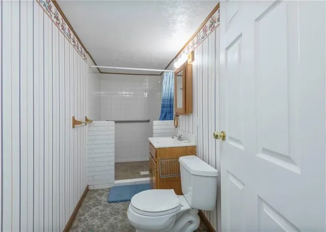 a white toilet sitting next to a bathroom sink and a shower