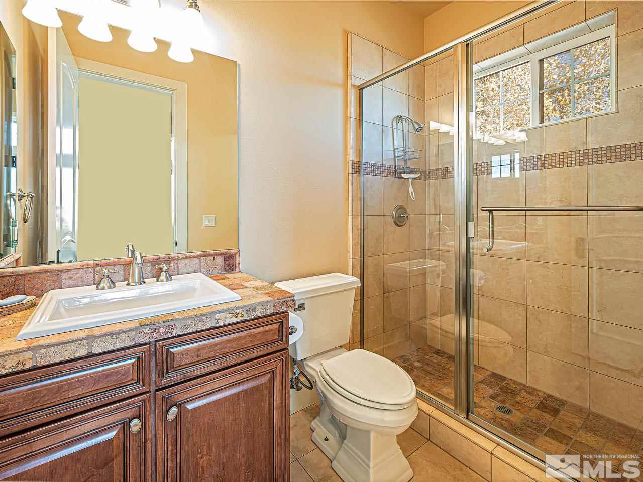 3644 Silver Vista Drive Reno, NV 89511 - Photo 20 of 40 a bathroom with a granite countertop sink a toilet and shower
