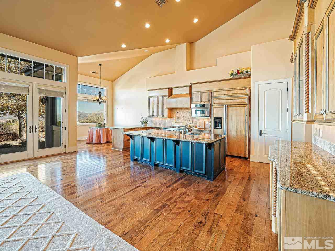 3644 Silver Vista Drive Reno, NV 89511 - Photo 8 of 40 a kitchen with stainless steel appliances kitchen island granite countertop a refrigerator a stove and a cabinets with wooden floor