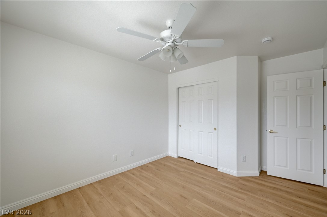8918 Houston Ridge Avenue Las Vegas, NV 89178 - Photo 28 of 35 A quiet bedroom featuring light wood flooring and a modern ceiling fan.