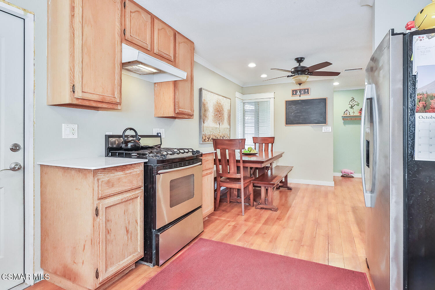 2248 Cutler Street Simi Valley, CA 93065 - Photo 18 of 41 a kitchen with stainless steel appliances granite countertop a stove top oven a sink a dining table and chairs with wooden floor