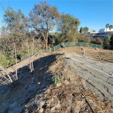 a view of a yard with wooden fence