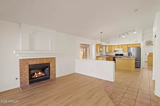 an empty room with windows and chandelier fan