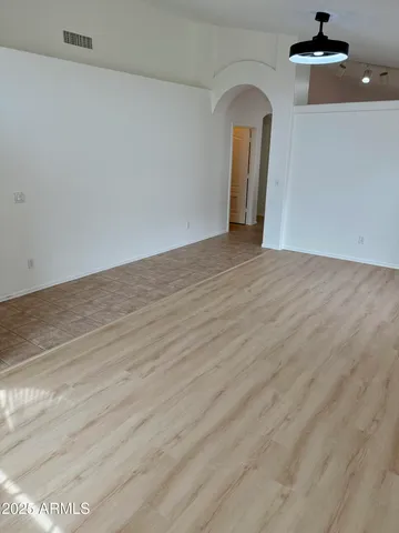 a view of a room with wooden floor and ceiling fan