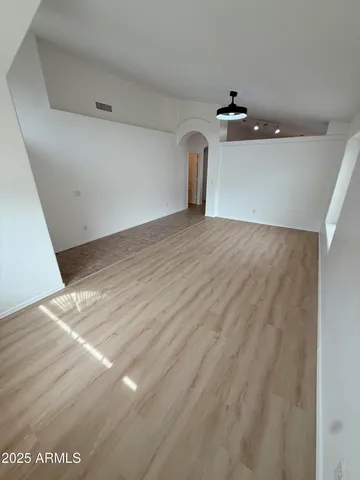 a view of empty room with wooden floor