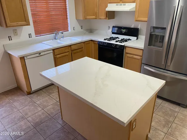 a kitchen with a sink a stove top oven and refrigerator