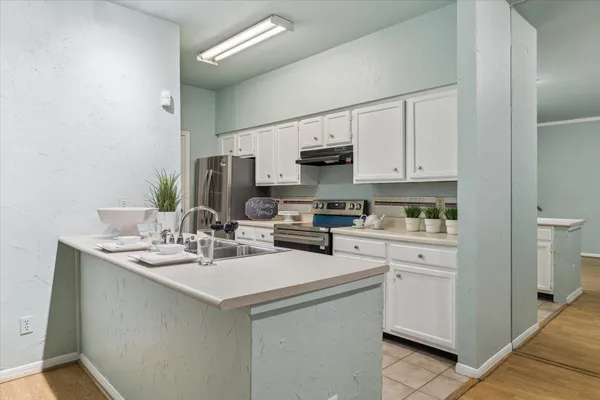 a kitchen with appliances a sink and cabinets