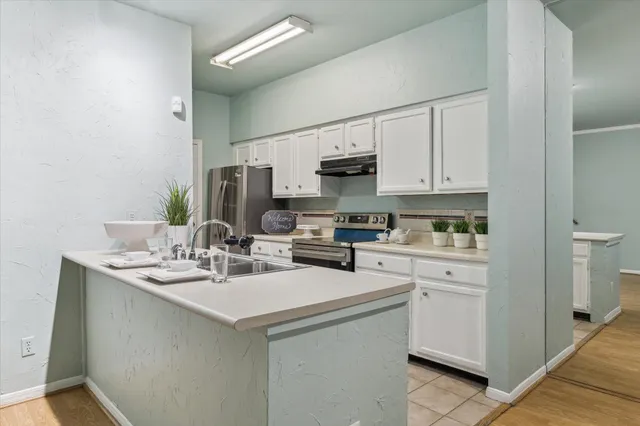 a kitchen with appliances a sink and cabinets