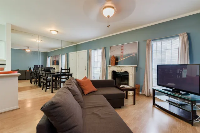 a living room with furniture a flat screen tv and a fireplace