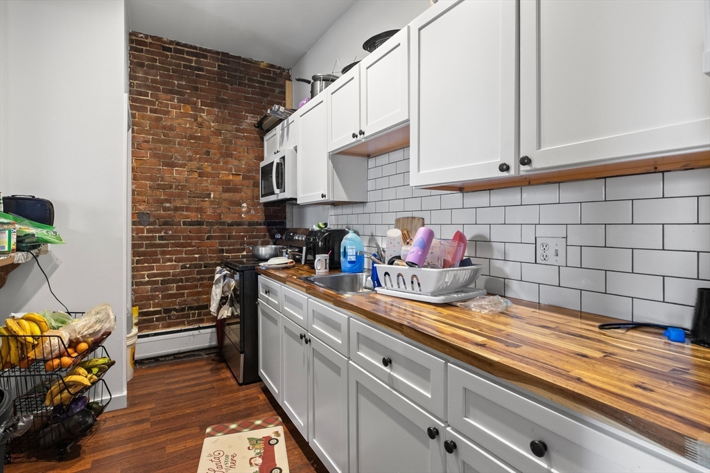 100-102 Main Street Gloucester, MA 01930 - Photo 34 of 40 a kitchen with blue cabinets and a stove