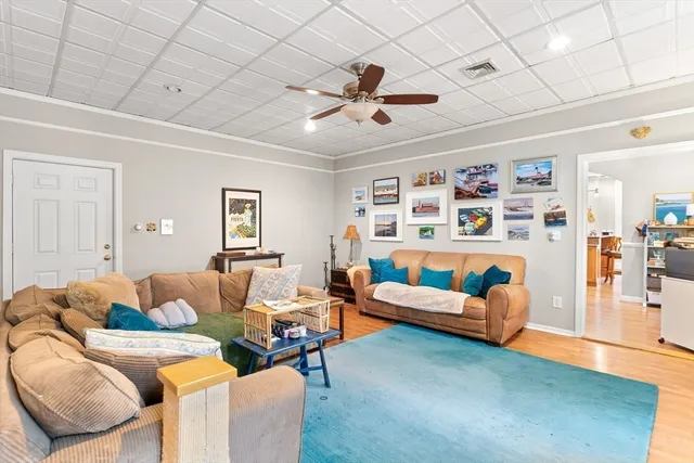 a living room with furniture and a wooden floor