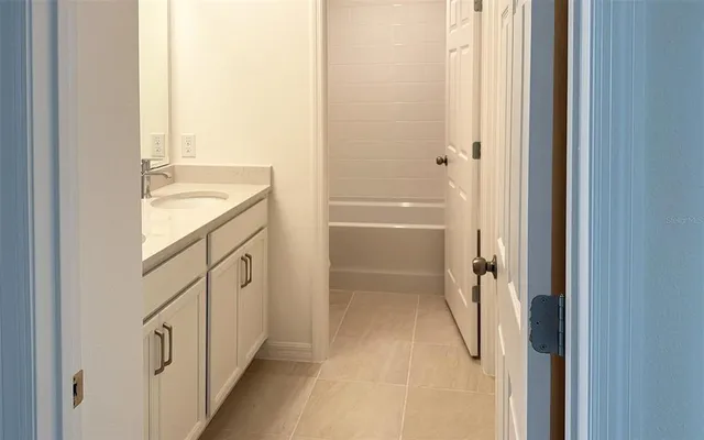 a bathroom with a granite countertop sink a mirror and a bathtub