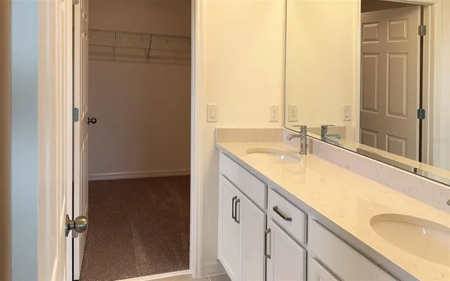 a bathroom with a granite countertop sink and a large mirror