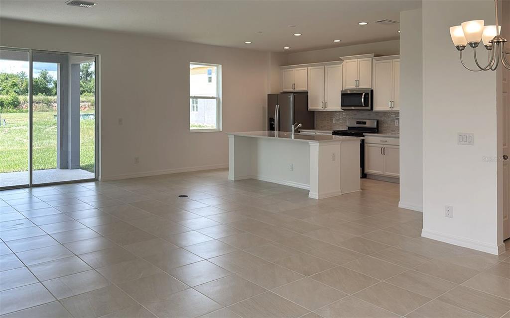 6867 Spanish Imperial Street Howey-in-the-Hills, FL 34737 - Photo 2 of 20 a kitchen with stainless steel appliances a refrigerator sink and microwave