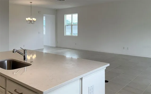 a view of a kitchen with a sink and chandelier