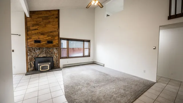 an empty room with fireplace and windows
