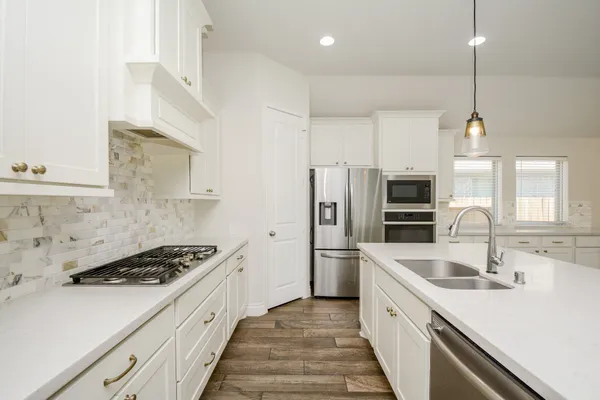 a kitchen with stainless steel appliances a refrigerator sink and cabinets