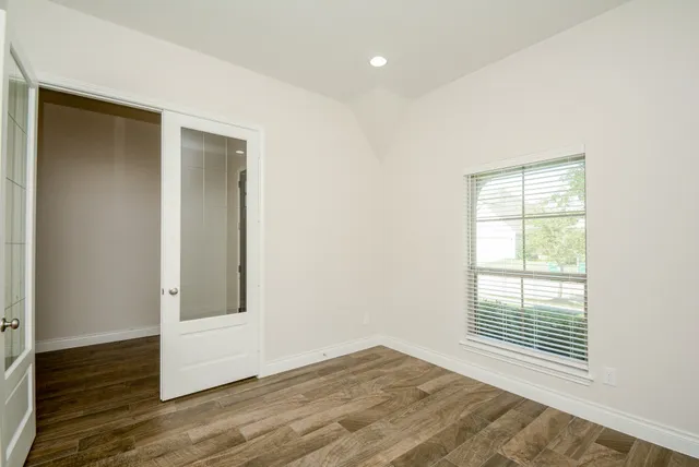 a kitchen with a white center island a wooden floor and white cabinets