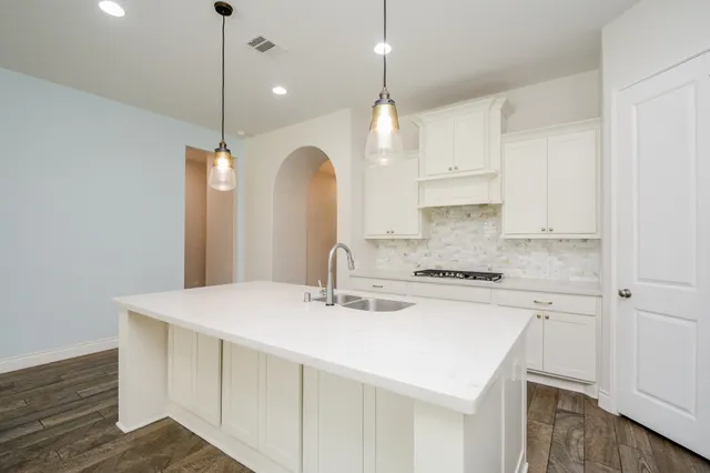 a kitchen with granite countertop white cabinets and white appliances