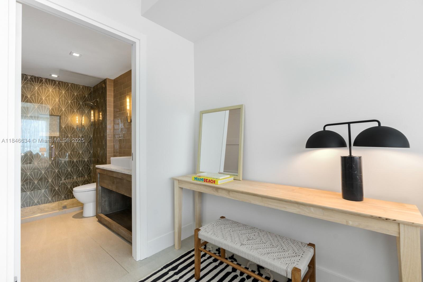 1 Collins Avenue, Unit 605 Miami Beach, FL 33139 - Photo 17 of 33 a bathroom with a sink and a mirror