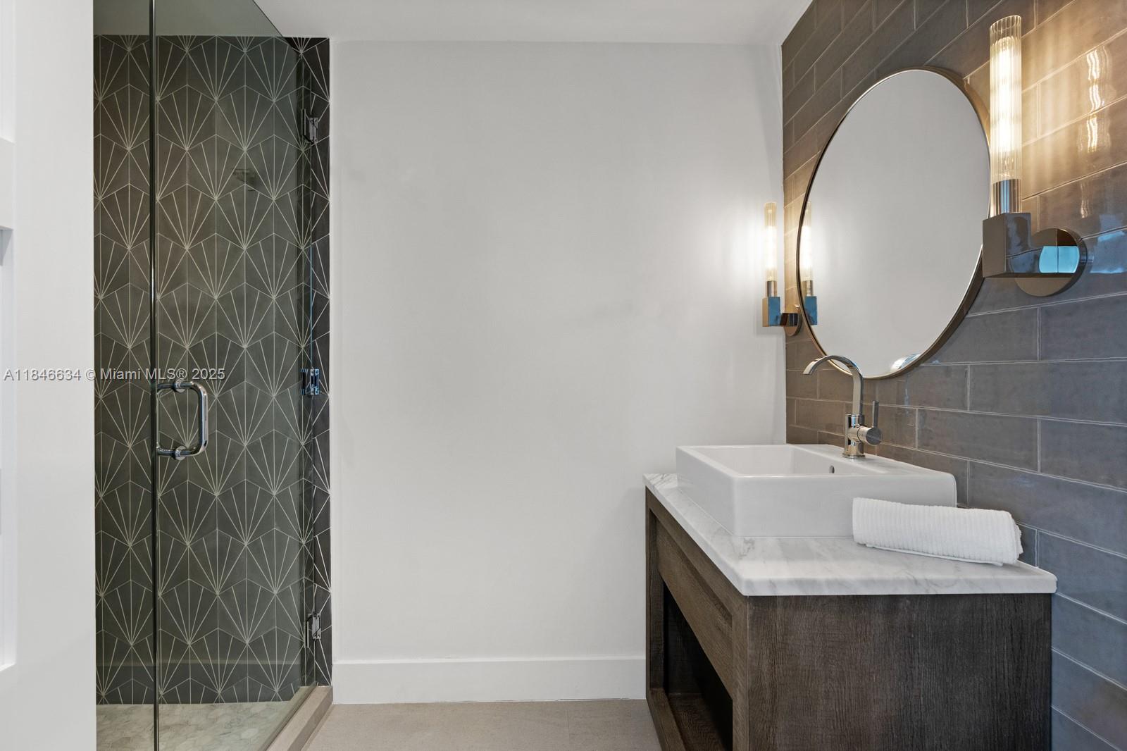 1 Collins Avenue, Unit 605 Miami Beach, FL 33139 - Photo 22 of 33 a bathroom with a sink and a mirror