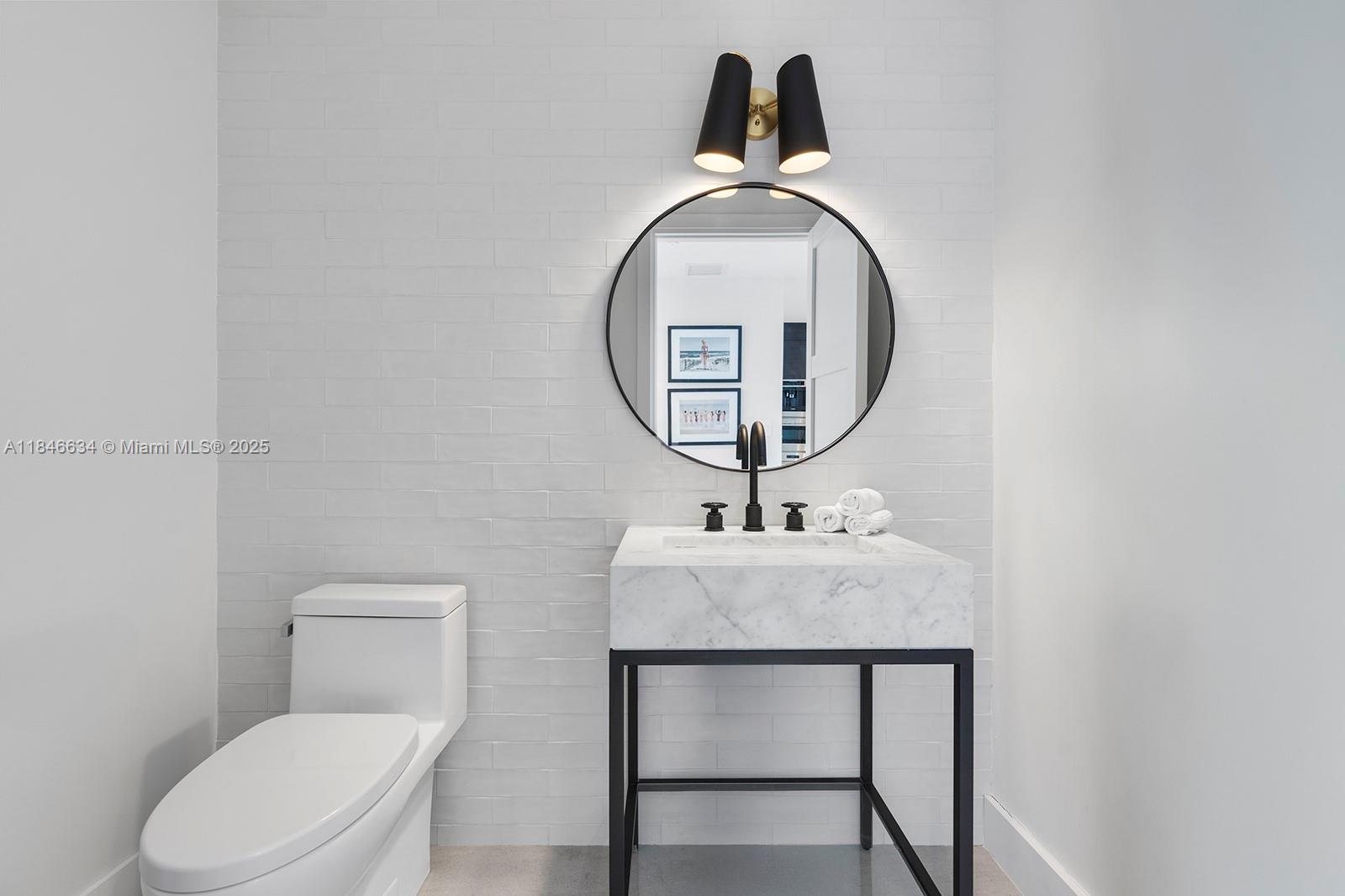 1 Collins Avenue, Unit 605 Miami Beach, FL 33139 - Photo 25 of 33 a bathroom with a toilet a sink and a mirror