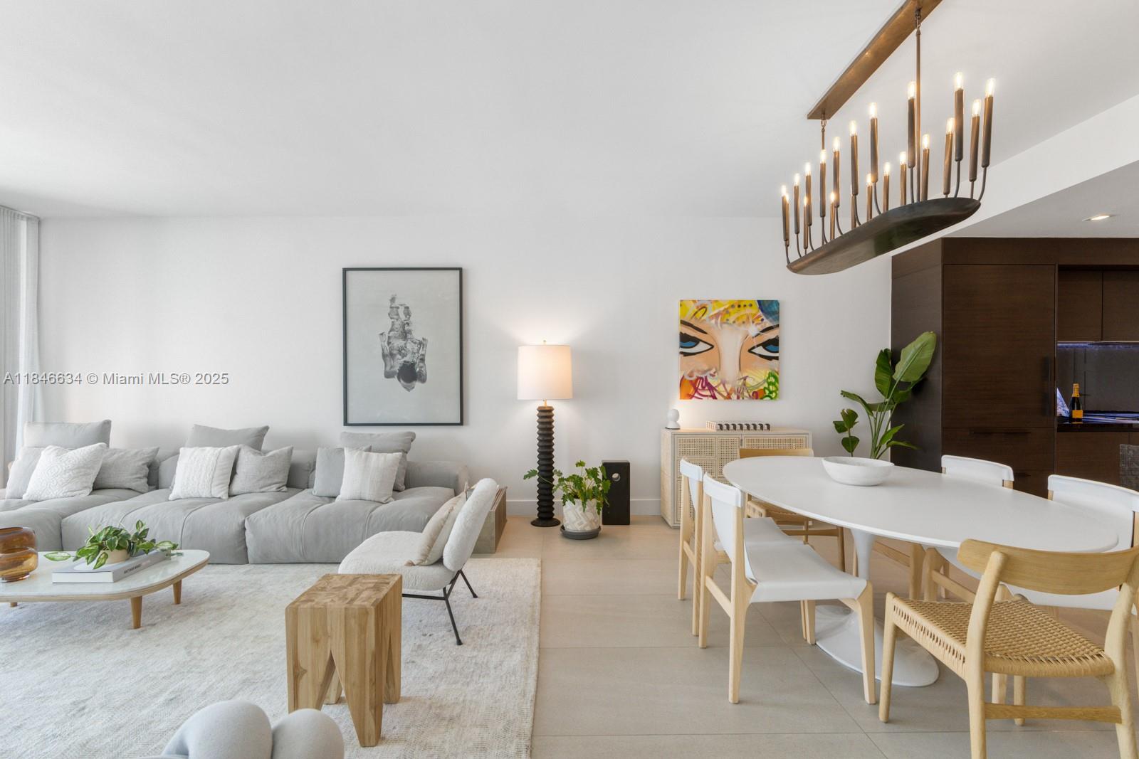 1 Collins Avenue, Unit 605 Miami Beach, FL 33139 - Photo 3 of 33 a living room with furniture a rug and a chandelier