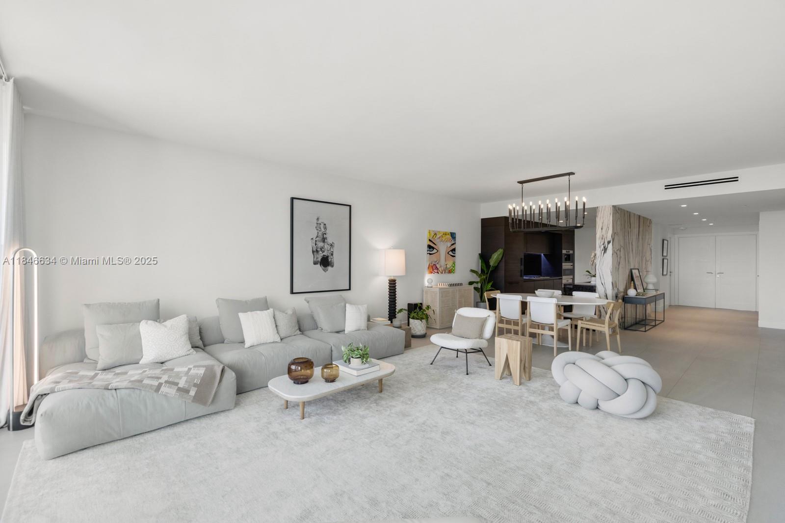 1 Collins Avenue, Unit 605 Miami Beach, FL 33139 - Photo 4 of 33 a living room with furniture and a flat screen tv