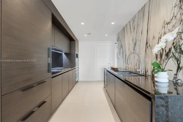 a kitchen with stainless steel appliances granite countertop a sink and stove top oven
