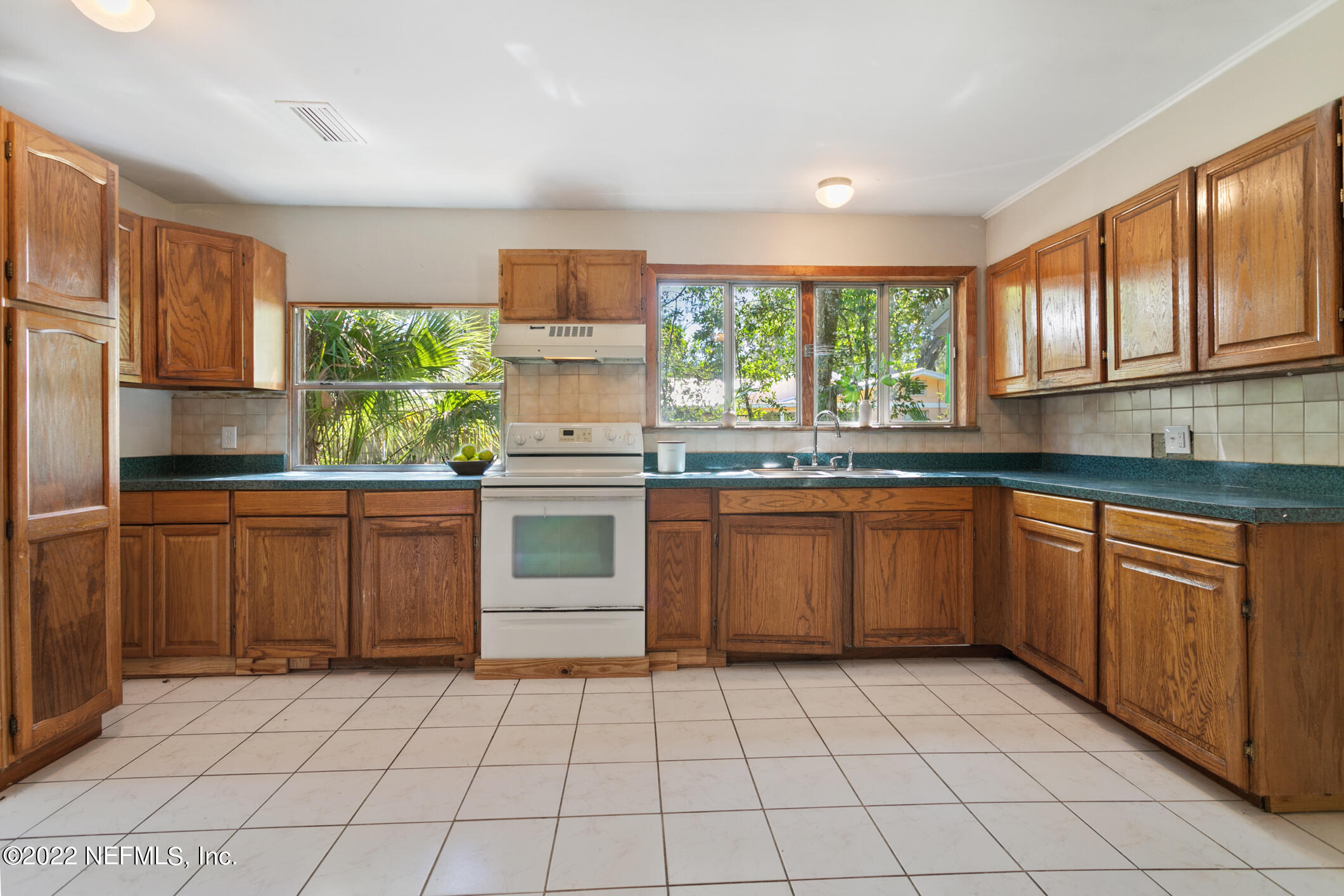 97 Spring Street St. Augustine, FL 32084 - Photo 8 of 18 a kitchen with a stove sink and cabinets