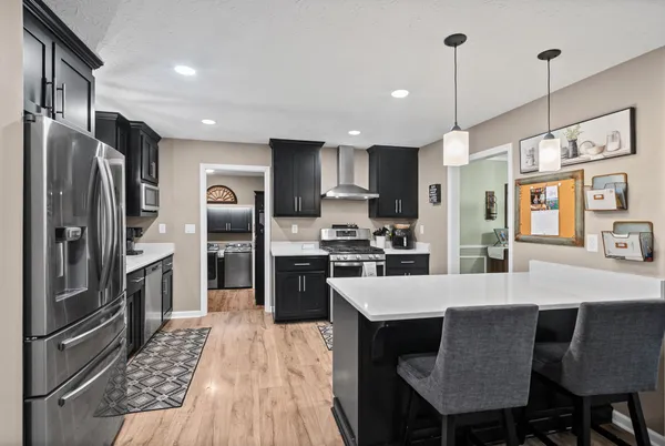 a large kitchen with granite countertop a counter space stainless steel appliances and cabinets