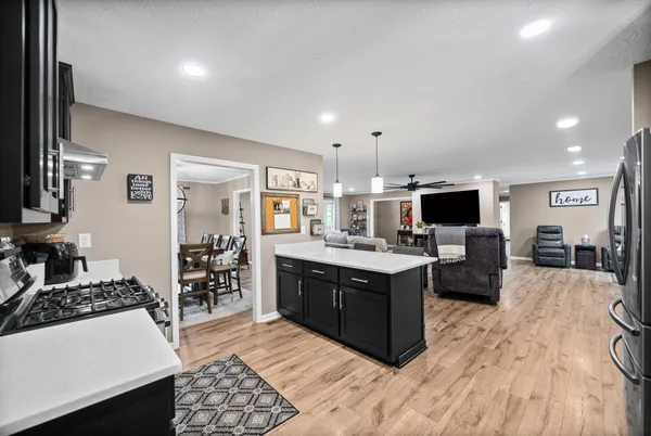 a large white kitchen with a large window and stainless steel appliances