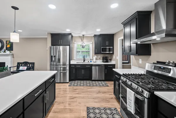 a kitchen with stainless steel appliances a sink stove and refrigerator