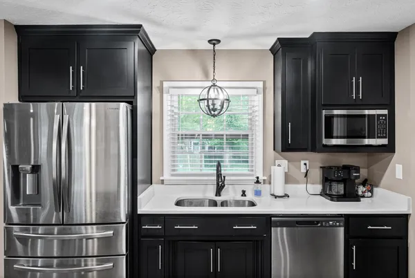 a kitchen with stainless steel appliances a sink and a refrigerator