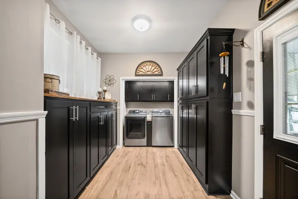 a view of a hallway with wooden floor cabinets and a kitchen