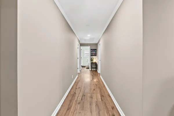 a view of a hallway with wooden floor and staircase