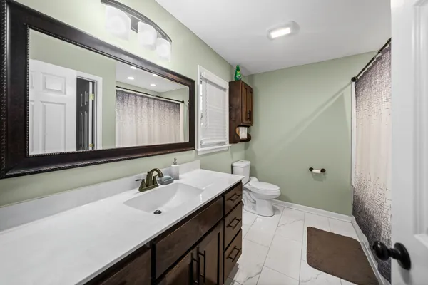 a bathroom with a double vanity sink toilet and mirror