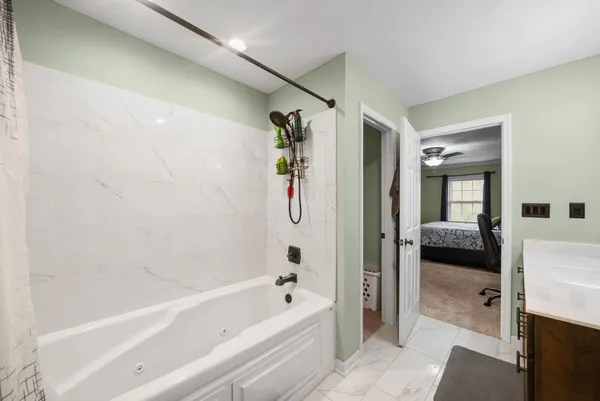 a en suite bathroom with a tub shower and a sink