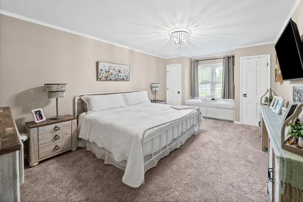 a spacious bedroom with a bed and a flat screen tv