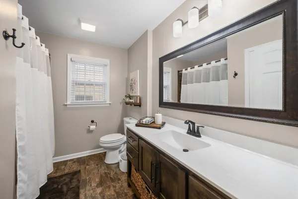 a bathroom with a sink mirror and a toilet