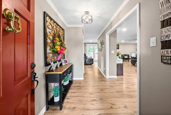 a hallway with painting on the wall and a potted plant