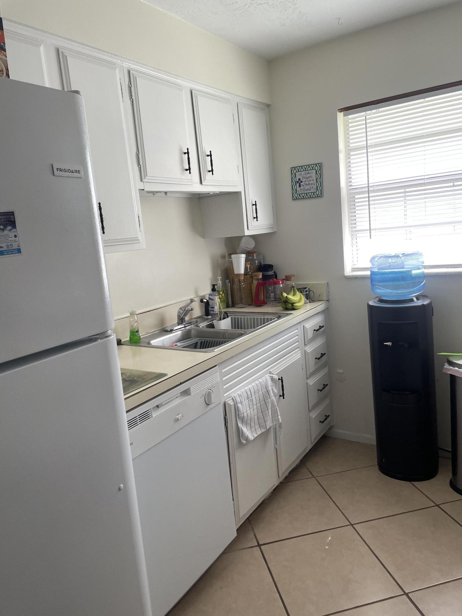 427 Count Street Melbourne, FL 32901 - Photo 4 of 9 a kitchen with stainless steel appliances white cabinets and a refrigerator