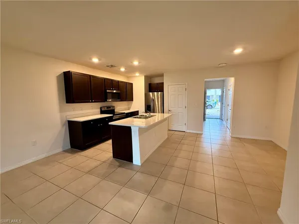 a large kitchen with stainless steel appliances a sink and a microwave