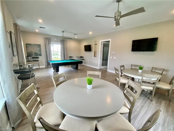 a view of a dining room with furniture a kitchen and chandelier