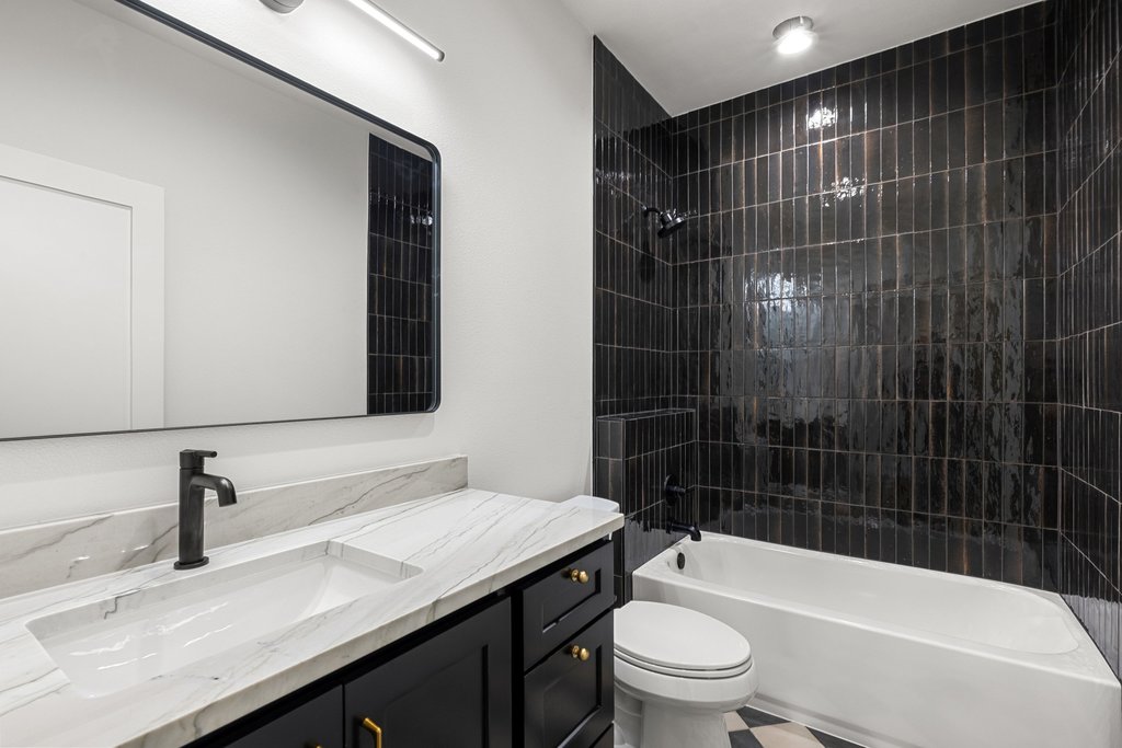 9207 Zyle Road Austin, TX 78737 - Photo 24 of 40 A well-appointed bathroom features a modern vanity with a single sink and a sleek dark tile shower.