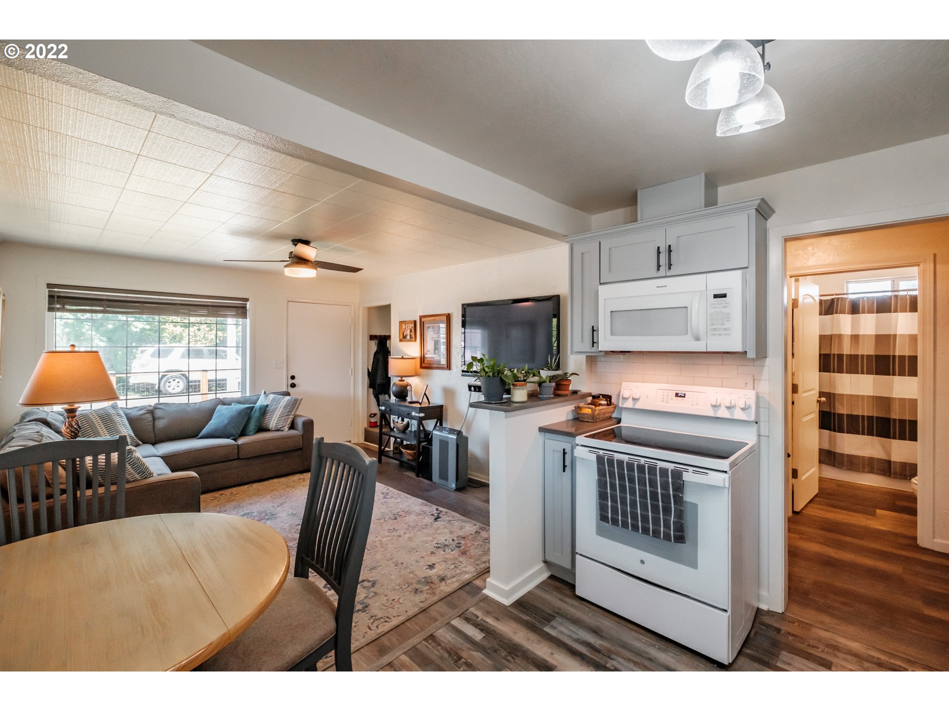 4235 Camellia Street Springfield, OR 97478 - Photo 8 of 27 a open kitchen with stainless steel appliances a stove a refrigerator a sink dishwasher with a dining table and chairs with wooden floor